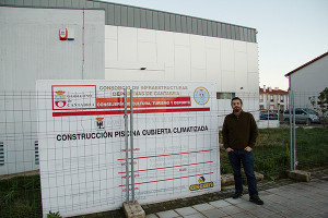 Jorge Crespo junto al Cartel de la obra de la piscina de Val